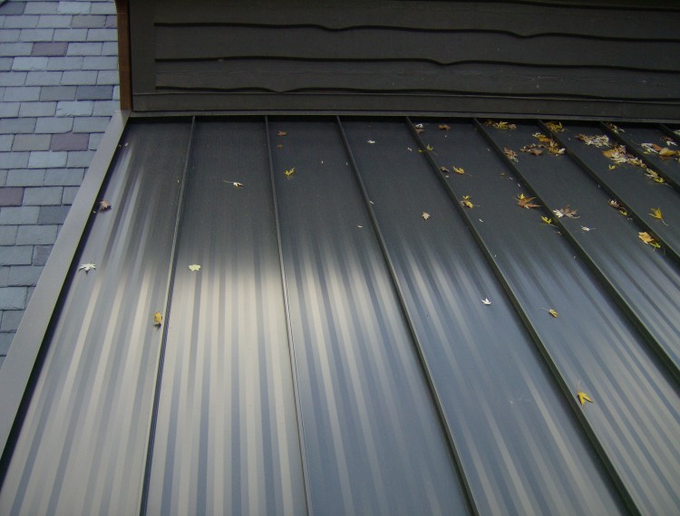 Standing seam painted steel roof - view of panel striations and headwall flashing.