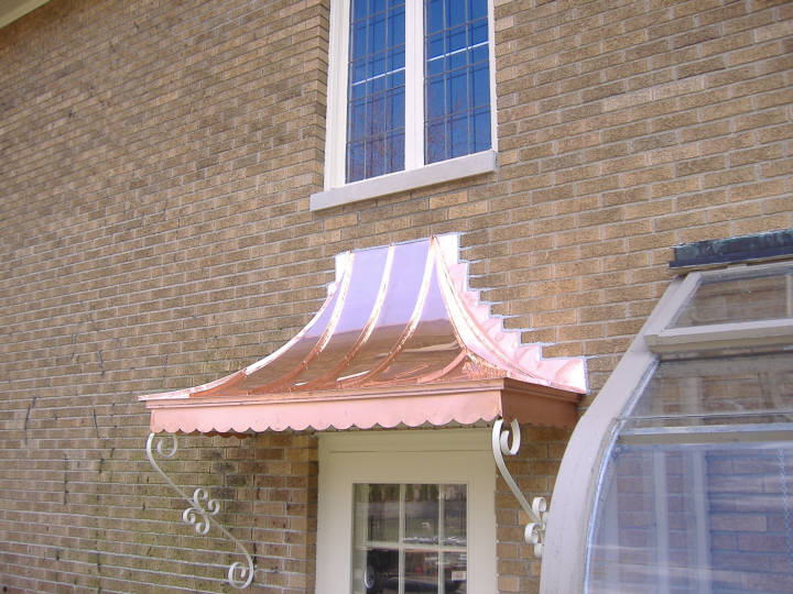 Custom copper awning with scalloped fascia.