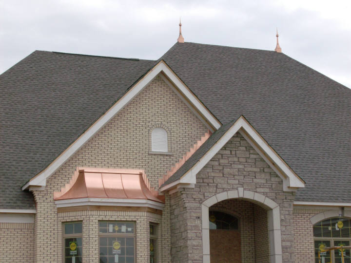 Custom copper bay window roof with stepped copper counter flashing, and gem-style copper finials, or spires.