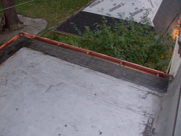 Custom copper half-round gutter, retro-fitted to a modified bitumen (aka Mod-Bit) flat roof.